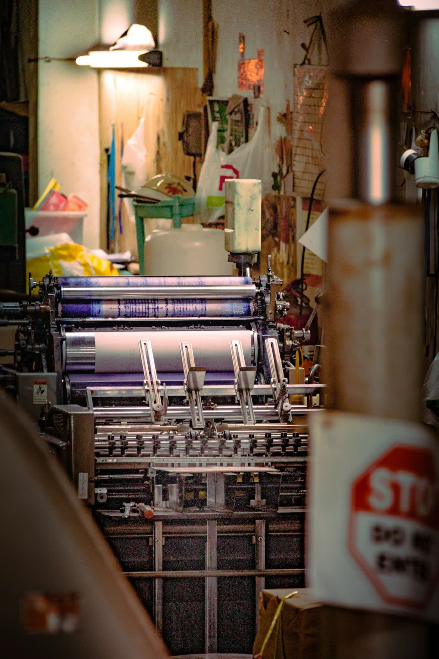Ink rollers and cylinders on an industrial printing press, with no people in the frame.